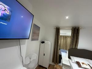 Krevet ili kreveti u jedinici u objektu 4TH Studio Flat a Family Luxury London Home A Fully Equipped and furnished Studio With a King Size Bed And a Futon-Sofa Bed A Baby Cot A Kitchenette With a Private Toilet and Bath a Garden For up to 4 Guests and Free Parking