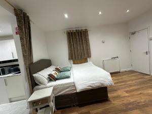Un dormitorio con una cama grande con almohadas. en 4TH Studio Flat a Family Luxury London Home A Fully Equipped and furnished Studio With a King Size Bed And a Futon-Sofa Bed A Baby Cot A Kitchenette With a Private Toilet and Bath a Garden For up to 4 Guests and Free Parking en Lewisham