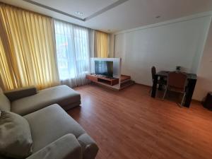 a living room with a couch and a flat screen tv at The Privilege Residence in Patong Beach