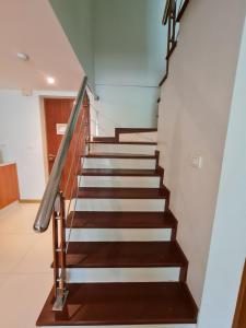 a staircase in a house with wood and metal railings at The Privilege Residence in Patong Beach