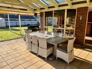 a patio with a table and chairs and a grill at Sea Renity - Pet Friendly in Robe