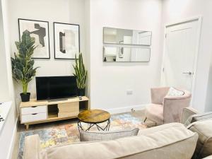 ein Wohnzimmer mit einem Sofa und einem TV in der Unterkunft Coastal Charm Comfort Home in Margate in Margate