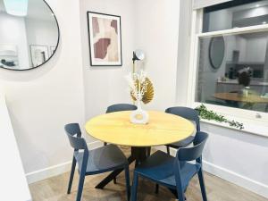 a dining room with a wooden table and blue chairs at Coastal Charm Comfort Home in Margate in Margate