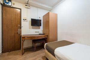吉隆坡的住宿－Grand Orchard Hotel Premier，一间卧室配有一张床和一张带一张桌子的桌子,一张桌子上配有一张高质量的床铺。