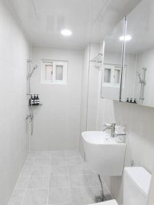 een witte badkamer met een wastafel en een toilet bij KINTEX Daewha Stay Kintex 5min Baek Hospital 1min Daewha Station 5min 킨텍스 대화스테이 in Goyang