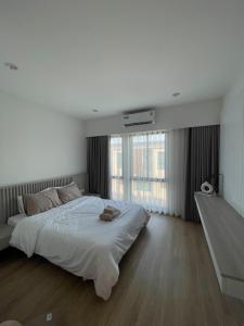 Un dormitorio blanco con una cama grande y una ventana en New Townhouse @Central Rayong en Rayong