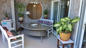 una mesa y sillas en un porche con espejo en CHEZ LORNA 5 nights minimum, en De Quincey Village