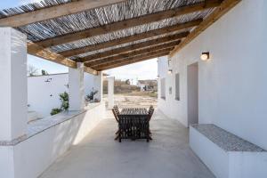 un patio con tavolo, sedie e soffitto in legno di Mas Midó a Sant Jaume d'Enveja