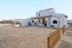 una casa bianca con una recinzione davanti di Mas Midó a Sant Jaume d'Enveja