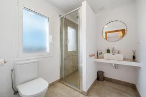 bagno bianco con servizi igienici e specchio di Mas Midó a Sant Jaume d'Enveja Altre 28 foto