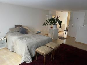 1 dormitorio con 1 cama grande y 2 taburetes en Atemberaubende Triplexwohnung in der Altstadt Zug en Zug
