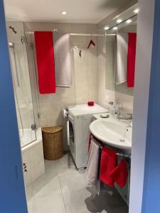y baño con lavabo, aseo y toallas rojas. en Atemberaubende Triplexwohnung in der Altstadt Zug en Zug