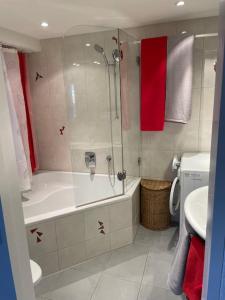 La salle de bains est pourvue d'une douche, d'une baignoire et d'un lavabo. dans l'établissement Atemberaubende Triplexwohnung in der Altstadt Zug, à Zoug