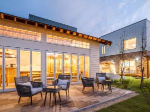 un patio con sillas y mesas frente a un edificio en AMAZING LIFESTYLE GLAMPING HOTEL - Vacation STAY 44042v, en Nagahama
