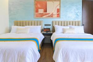 two beds in a room with blue walls at Magarra Hotel in Orani