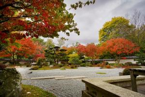 a garden with colorful trees and a stone path at Hotel Lindenhof in Bielefeld