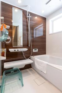 a bathroom with a tub and a sink at Furano Trailer Village Den in Furano