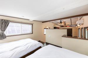 1 dormitorio con 2 camas y ventana en Furano Trailer Village Den en Furano