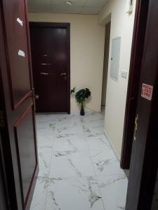 a hallway with a black door and a marble floor at YOUR HOME in Dubai