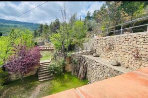 a stone building with stairs and a stone wall at Casa Rural La Garcia in Puebla de Arenoso