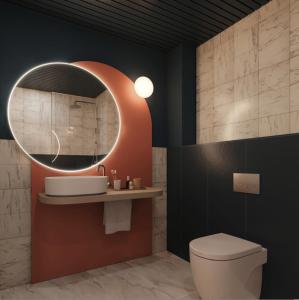 een badkamer met een toilet en een ronde spiegel bij Onix Fira in Barcelona