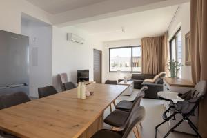 Nelia Panorama Villa في بروتاراس: غرفة معيشة مع طاولة وكراسي خشبية كبيرة