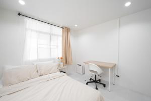 a bedroom with a bed and a desk and a window at Cozy home near city and air port in Chiang Mai
