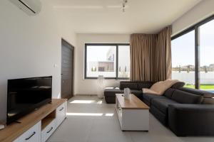 a living room with a couch and a flat screen tv at Nelia Panorama Villa in Protaras