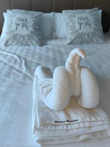 a towel animal is sitting on a bed at Jesselton Quay by Miraton Lodge 2 in Kota Kinabalu
