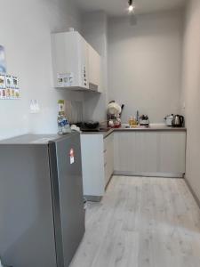 a kitchen with white cabinets and a stainless steel refrigerator at Jesselton Quay by Miraton Lodge 2 in Kota Kinabalu