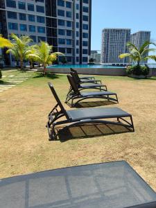 Jesselton Quay by Miraton Lodge 2 في كوتا كينابالو: صف من كراسي الجلوس في الحديقة