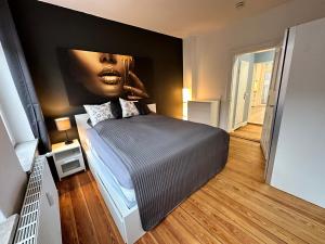 a bedroom with a bed with a painting on the wall at TOP Altbauwohnung in Kiel Mitte in Kiel