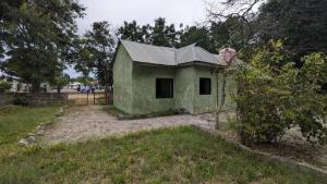 un petit bâtiment vert au milieu d'un champ dans l'établissement Tripple H rent House, à Kilindoni