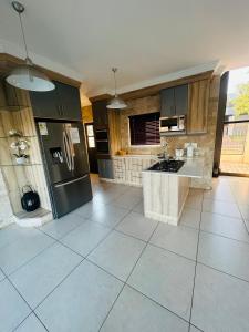 a kitchen with stainless steel appliances and a tile floor at Bluewave Lifestyle Villa in Hartbeespoort