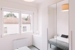 a white bathroom with a mirror and a window at Appartamenti Autodromo in Imola