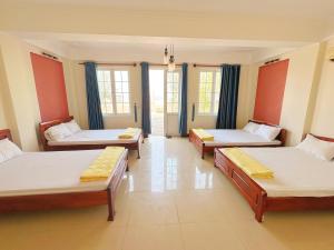 Zimmer mit 3 Betten und Fenstern in der Unterkunft Hải Yến Hotel Quảng Bình in Quang Binh