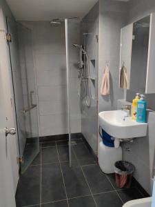 W łazience znajduje się prysznic i umywalka. w obiekcie Jesselton Quay by Miraton Lodge 1 w mieście Kota Kinabalu