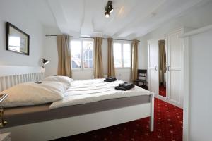 um quarto com uma cama grande num quarto com janelas em THE CORNISH ARMS Guest House em Solingen