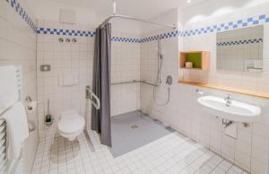 a bathroom with a shower and a toilet and a sink at Hotel Lindenhof in Bielefeld