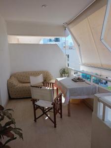 uma sala de estar com um sofá, uma mesa e cadeiras em Dancer's Home em Corinto