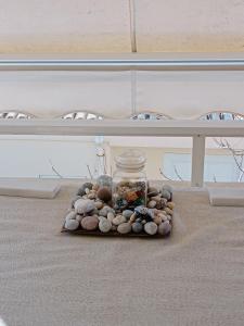 um frasco cheio de pedras numa mesa numa sala em Dancer's Home em Corinto