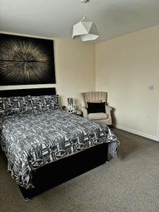 a bedroom with a bed and a chair at Hatley Residencies in Dudley