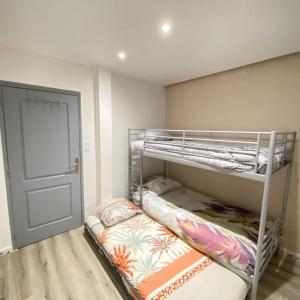 a room with two bunk beds and a door at Les Cèdres in Morbier