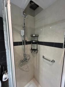 y baño con ducha y azulejos blancos y negros. en Terraza Albir, en Albir