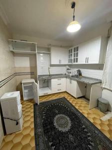 an empty kitchen with white cabinets and a rug at Geniş aileler için ideal daire in Istanbul