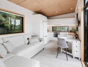 a living room with a white couch and a kitchen at Hot Springs Retreat + Sapphire Springs Pools in Tahawai