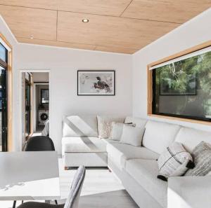 a living room with a white couch and a tv at Hot Springs Retreat + Sapphire Springs Pools in Tahawai