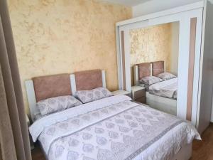 een slaapkamer met 2 bedden en een grote spiegel bij Cozy Apartment- zona centrala in Bacău