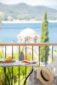 - une table avec un chapeau et une boisson sur un balcon dans l'établissement Liotopi, à Olympiada