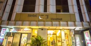 una tienda frente a un edificio con un cartel. en Hotel CJ International, en Amritsar